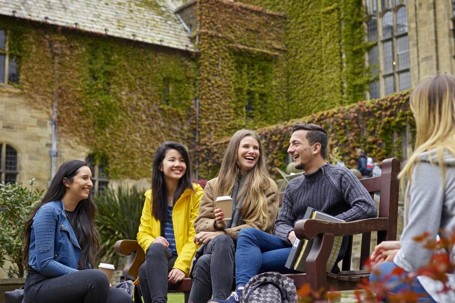 Students socialising on a bench in the inner quad of the University's Main Arts building